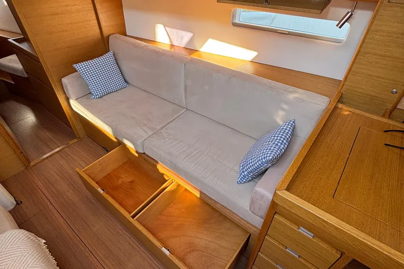 Abide Yacht Photos Pics Interior of 2018 X-Yachts X4.9 with beige sofa, storage, and wooden finish.