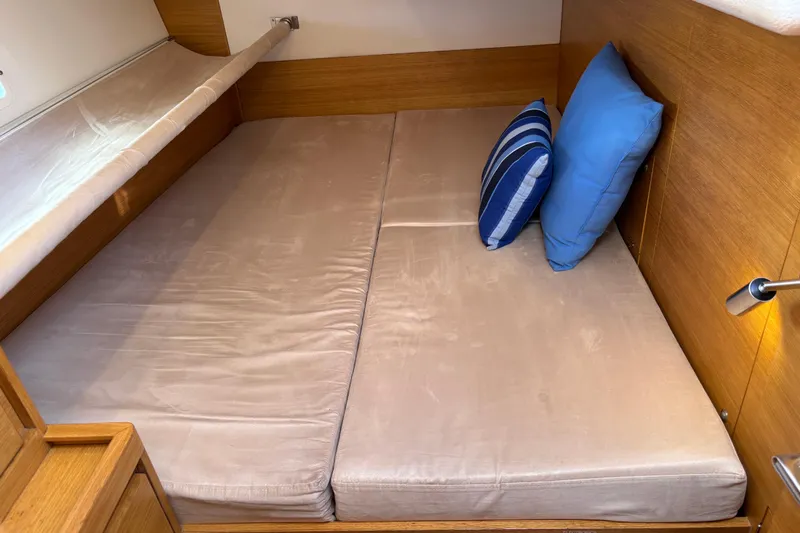 Abide Yacht Photos Pics Cozy cabin interior of 2018 X-Yachts X4.9 with cushions and wooden finish.
