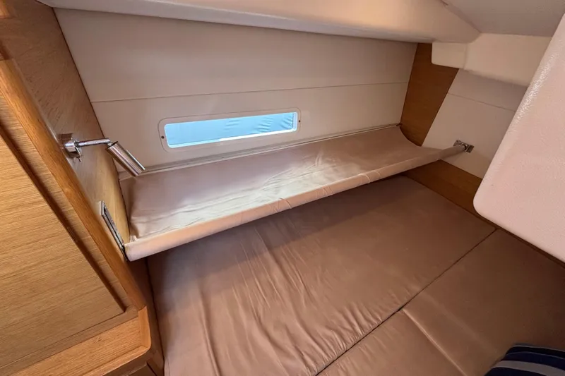Abide Yacht Photos Pics 2018 X-Yachts X4.9 interior cabin with cozy bedding and wooden accents.
