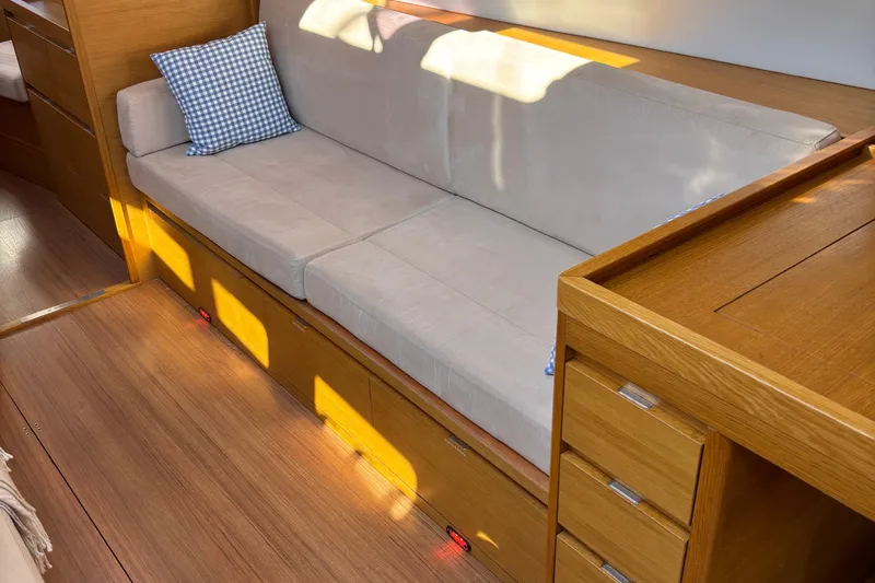 Abide Yacht Photos Pics Interior of 2018 X-Yachts X4.9 featuring a beige sofa and wooden cabinetry.