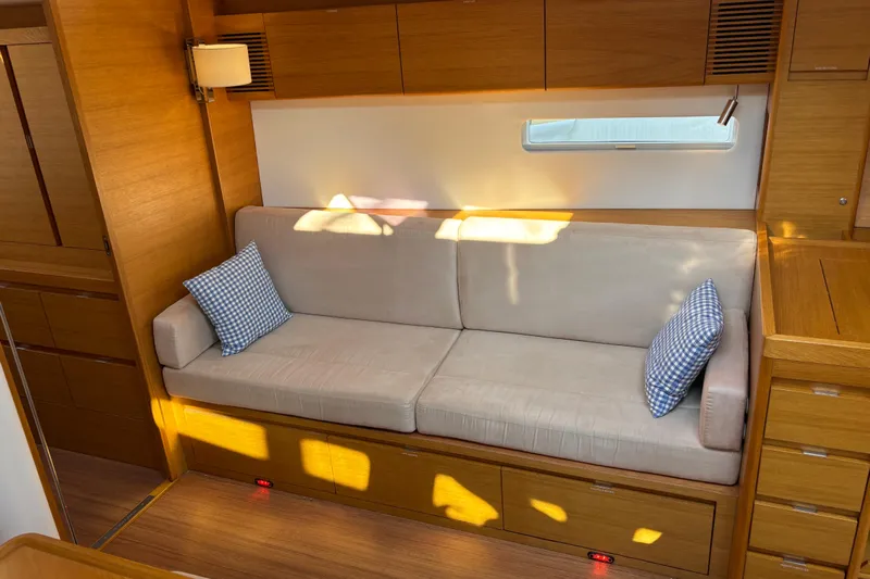Abide Yacht Photos Pics Interior of 2018 X-Yachts X4.9 with beige sofa and blue checkered pillows.