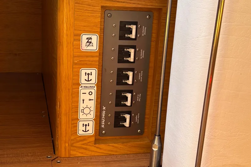 Abide Yacht Photos Pics Control panel on 2018 X-Yachts X4.9, featuring switches and icons on wooden interior.