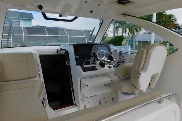  Yacht Photos Pics 2019 Pursuit OS 325 Offshore boat interior with helm, steering wheel, and seating.