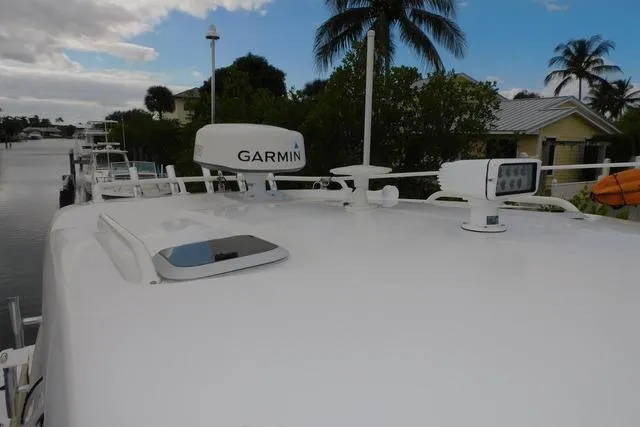  Yacht Photos Pics 2019 Pursuit OS 325 Offshore boat with Garmin radar, docked near palm trees.