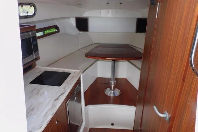  Yacht Photos Pics 2019 Pursuit OS 325 Offshore cabin interior with kitchenette and dining area.