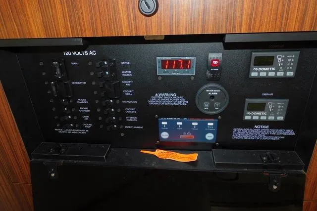  Yacht Photos Pics Electrical control panel of 2019 Pursuit OS 325 Offshore boat, featuring various switches and displays.