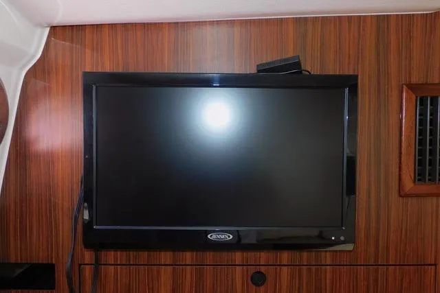  Yacht Photos Pics Flat-screen TV mounted on wood paneling inside a 2019 Pursuit OS 325 Offshore boat.