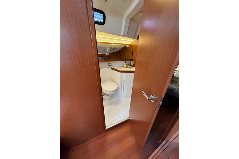 Run For The Roses Yacht Photos Pics Interior view of 2019 Beneteau Oceanis 46.1 yacht bathroom with wooden door and modern fixtures.
