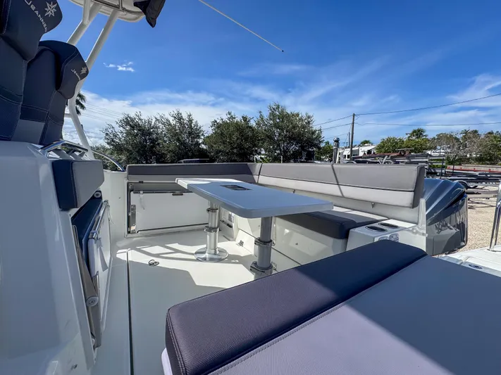 Mi Caleta Yacht Photos Pics 2023 Jeanneau Leader 9.0 WA boat interior with seating and table under clear blue sky.
