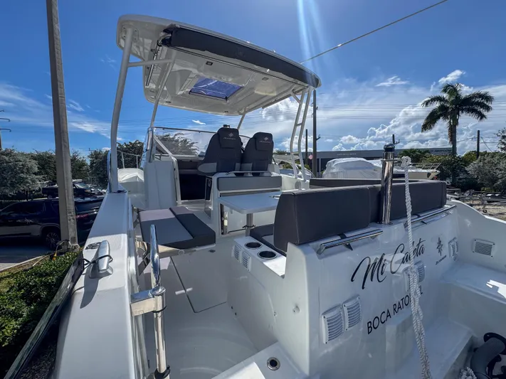Mi Caleta Yacht Photos Pics 2023 Jeanneau Leader 9.0 WA boat with seating, under a clear blue sky.