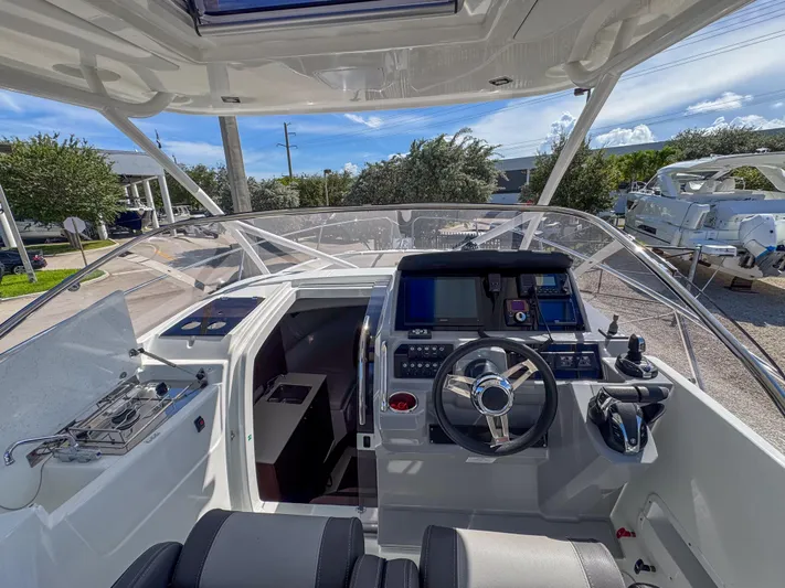 Mi Caleta Yacht Photos Pics 2023 Jeanneau Leader 9.0 WA boat cockpit with modern controls and navigation equipment.