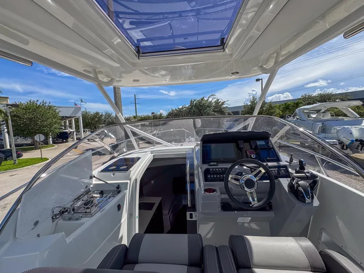 Mi Caleta Yacht Photos Pics 2023 Jeanneau Leader 9.0 WA cockpit with modern controls and seating under a clear sky.