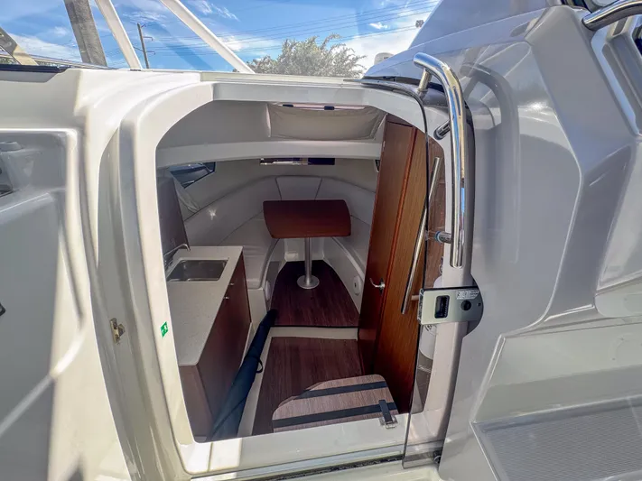 Mi Caleta Yacht Photos Pics 2023 Jeanneau Leader 9.0 WA cabin interior with kitchenette and seating area.