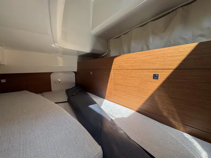 Mi Caleta Yacht Photos Pics 2023 Jeanneau Leader 9.0 WA cabin interior with wood paneling and cushioned seating.
