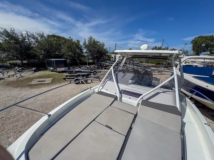 Mi Caleta Yacht Photos Pics 2023 Jeanneau Leader 9.0 WA boat with spacious deck, parked outdoors under clear blue sky.
