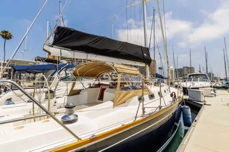 Kamala Yacht Photos Pics Sailboat docked at marina, Tartan 3700 model, 2003, with beige canopy and black sail cover.