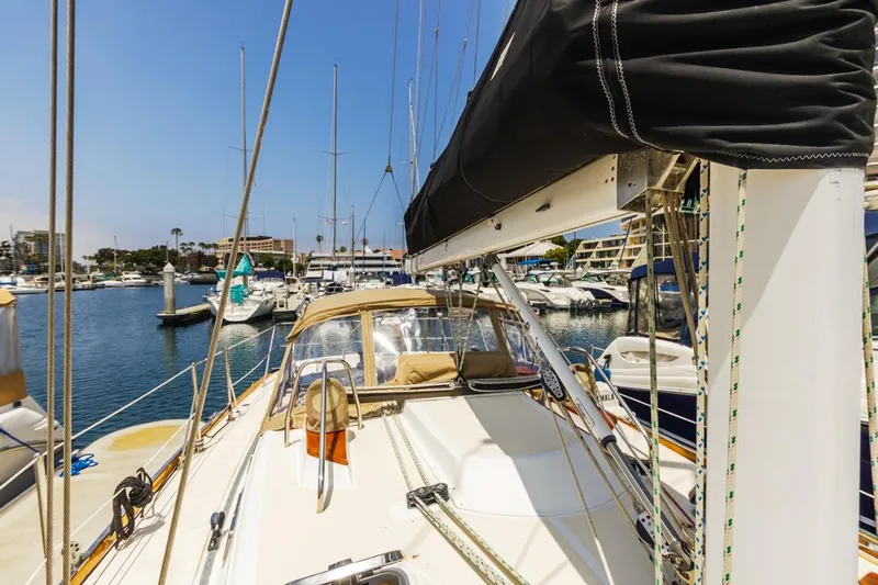 Kamala Yacht Photos Pics Sailboat Tartan 3700, 2003 model, docked in a marina under clear blue skies.