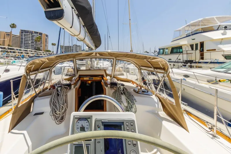 Kamala Yacht Photos Pics Tartan 3700 sailboat cockpit view, 2003 model, docked in a marina with surrounding yachts.