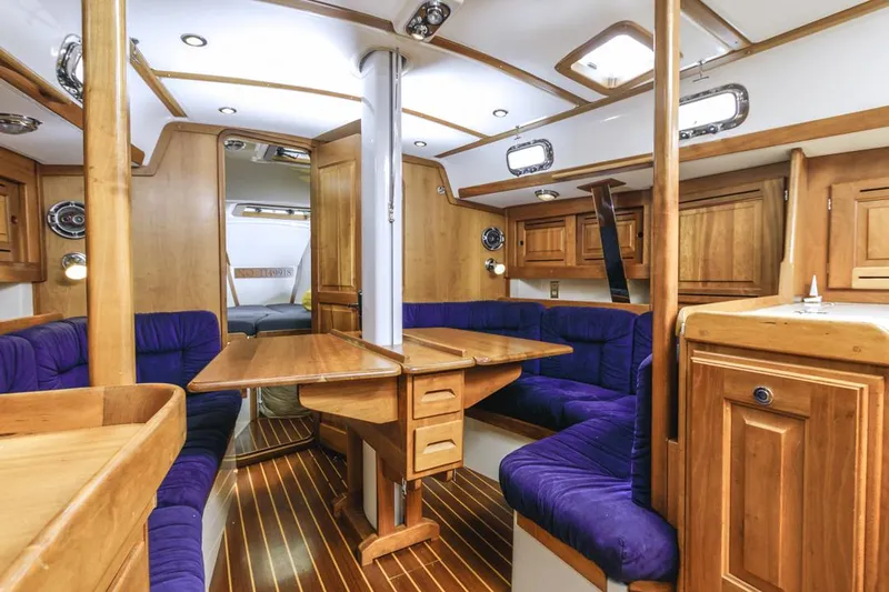 Kamala Yacht Photos Pics Luxurious interior of 2003 Tartan 3700 sailboat with wooden finish and plush seating.