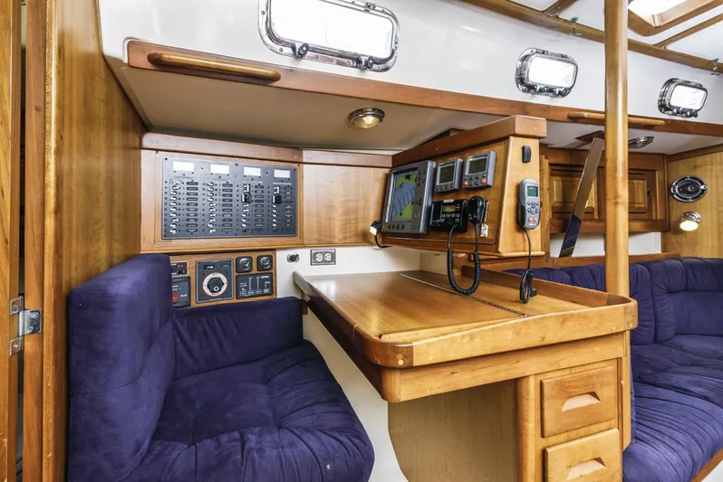 Kamala Yacht Photos Pics Interior of 2003 Tartan 3700 sailboat with navigation station and blue seating.