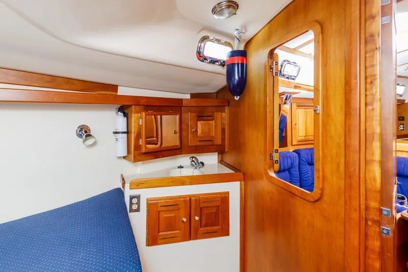 Kamala Yacht Photos Pics 2003 Tartan 3700 yacht interior with wooden cabinetry and blue upholstery.