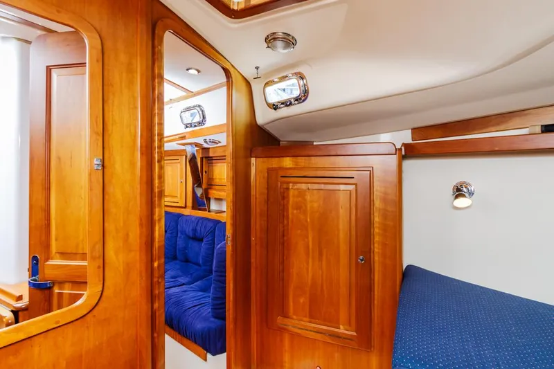 Kamala Yacht Photos Pics Interior of 2003 Tartan 3700 yacht with wooden cabinetry and blue seating.