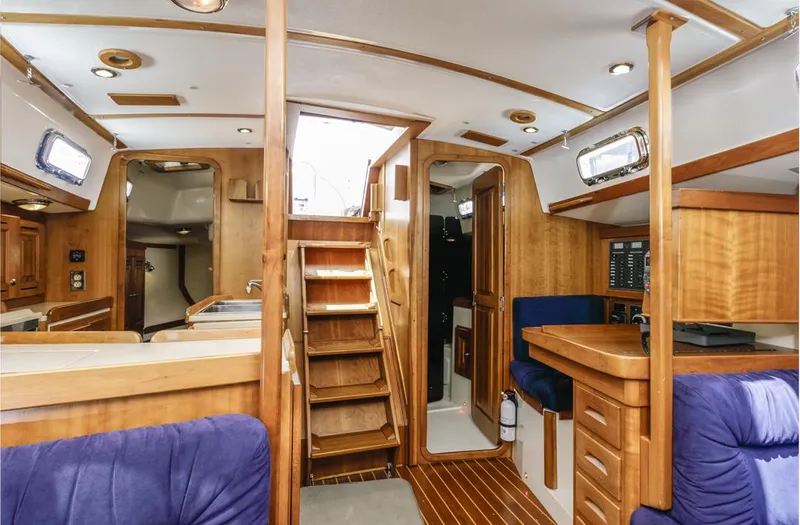 Kamala Yacht Photos Pics Interior of 2003 Tartan 3700 sailboat with wooden finishes and blue seating.
