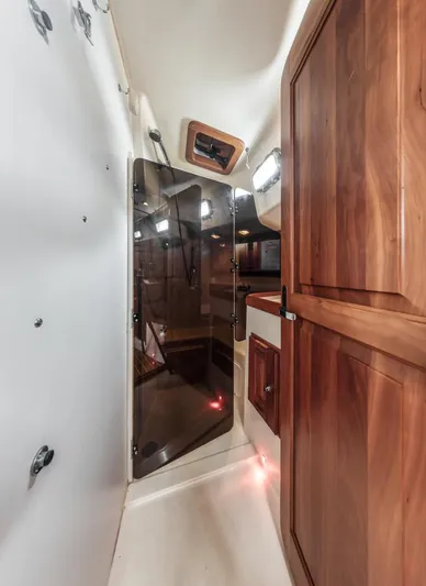 Kamala Yacht Photos Pics Interior of 2003 Tartan 3700 sailboat with wooden cabinetry and glass door.