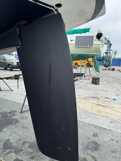 Kamala Yacht Photos Pics Close-up of a Tartan 3700 sailboat rudder, 2003 model, in a boatyard setting.