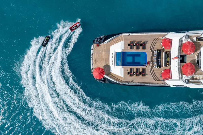 Alfa Nero Yacht Photos Pics Aerial view of 2007 Oceanco 269' yacht with pool, jet skis, and red umbrellas.