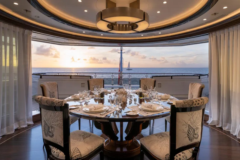 Alfa Nero Yacht Photos Pics Luxurious dining area on 2007 Oceanco yacht, elegant table setting, ocean view at sunset.
