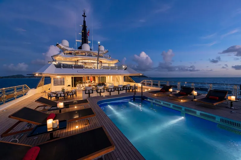 Alfa Nero Yacht Photos Pics Luxurious 2007 Oceanco 269' yacht deck with pool, lounge chairs, and ocean view at sunset.