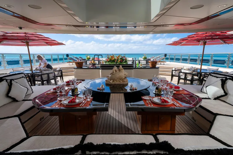 Alfa Nero Yacht Photos Pics Luxurious Oceanco 269' yacht deck with elegant dining setup, ocean view, and red umbrellas, 2007 model.