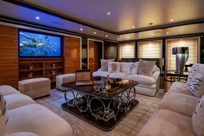 Alfa Nero Yacht Photos Pics Luxurious yacht interior with plush seating, elegant decor, and a large screen displaying marine life.