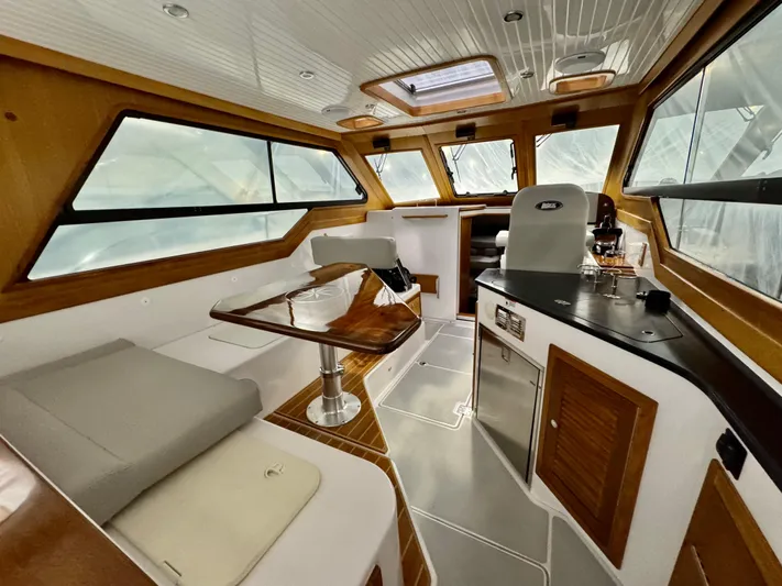 Omega Yacht Photos Pics Interior of 2022 True North 34 Outboard Express boat with modern kitchen and seating area.