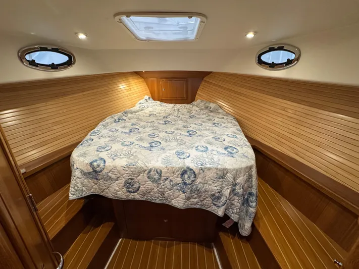 Omega Yacht Photos Pics 2022 True North 34 Outboard Express cabin with cozy bed and wooden interior.