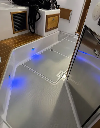 Omega Yacht Photos Pics 2022 True North 34 Outboard Express interior with modern flooring and ambient blue lighting.