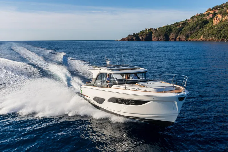  Yacht Photos Pics 2026 Marex 440 Gourmet Cruiser navigating ocean near rocky coastline.