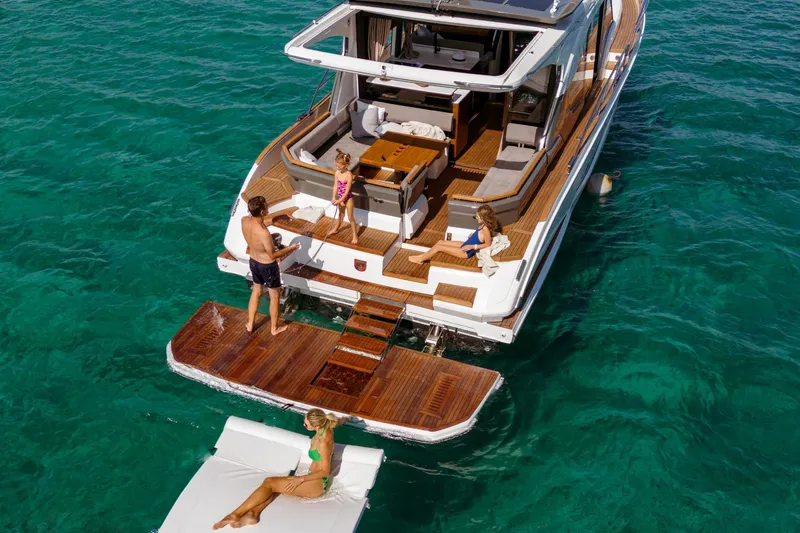  Yacht Photos Pics 2026 Marex 440 Gourmet Cruiser on turquoise water, featuring a spacious deck with people relaxing.