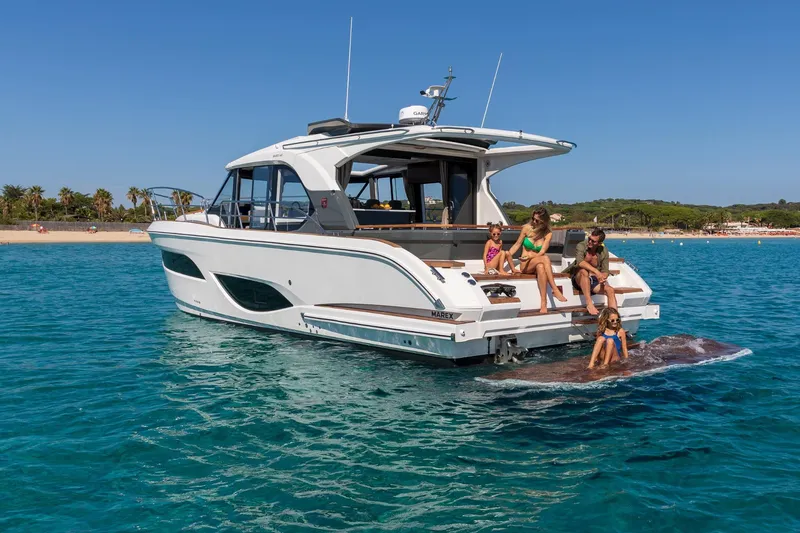  Yacht Photos Pics 2026 Marex 440 Gourmet Cruiser with family enjoying the ocean near a sandy beach.