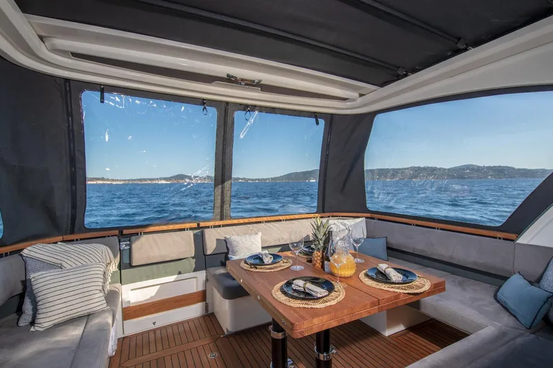  Yacht Photos Pics Luxurious interior of 2026 Marex 440 Gourmet Cruiser with ocean view and elegant dining setup.