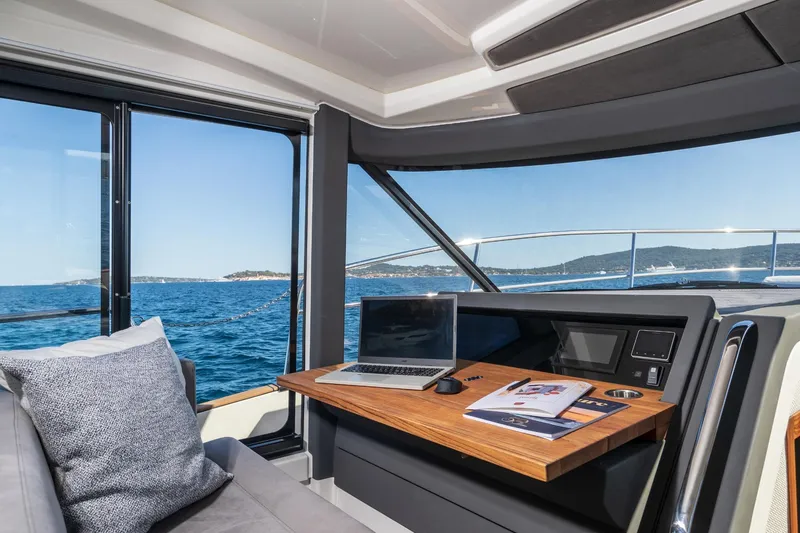  Yacht Photos Pics Interior of 2026 Marex 440 Gourmet Cruiser with ocean view, laptop, and brochures.