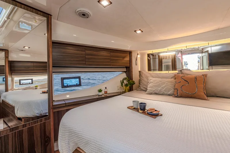  Yacht Photos Pics Luxurious bedroom interior of 2026 Marex 440 Gourmet Cruiser yacht with ocean view.