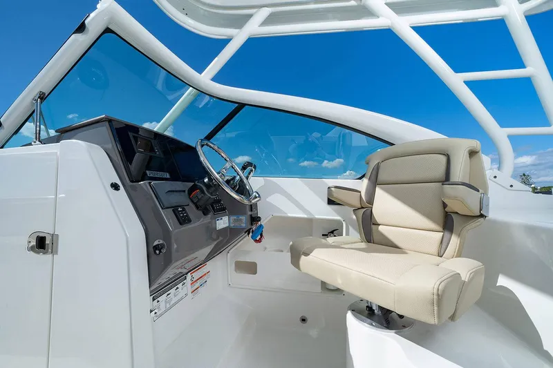 T/t Lucky Seven Yacht Photos Pics Manufacturer Provided Image: 2022 Pursuit DC 266 Dual Console boat interior with captain's chair and steering console.
