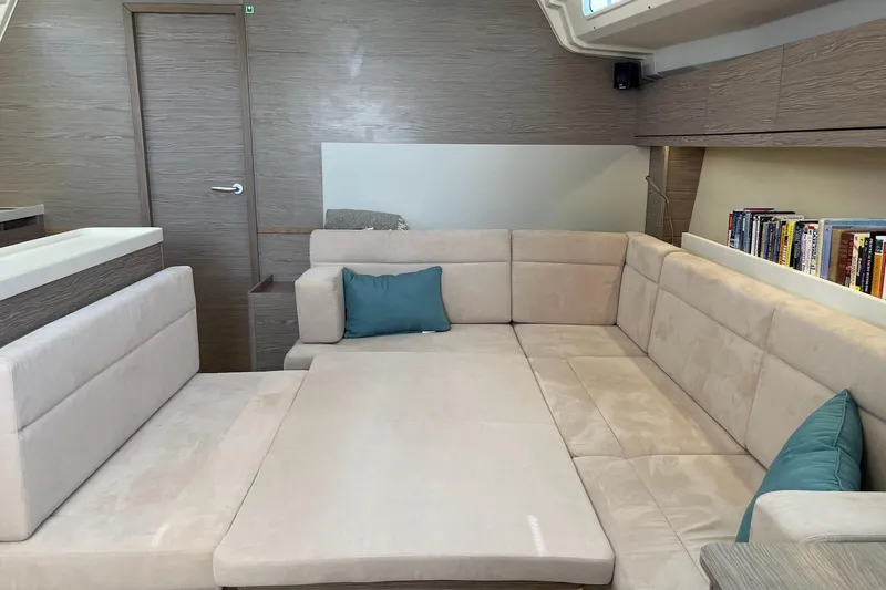 Eto Mio Yacht Photos Pics Luxurious interior of 2021 Hanse 508 yacht with beige seating and bookshelf.