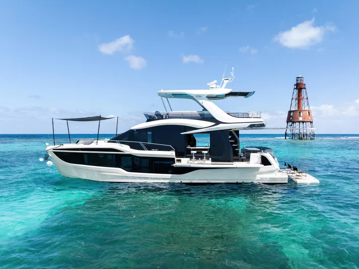 Dad Bod Yacht Photos Pics 2024 Galeon 560 Fly yacht on clear blue ocean near a lighthouse.
