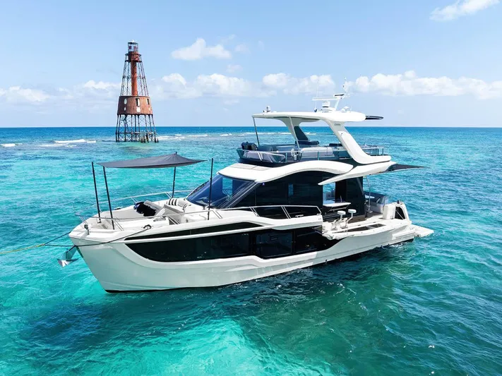 Dad Bod Yacht Photos Pics 2024 Galeon 560 Fly yacht on turquoise water near a lighthouse.