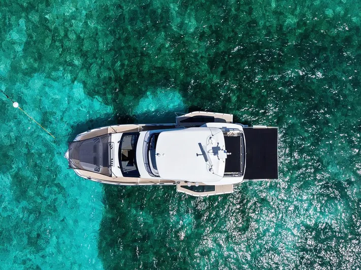 Dad Bod Yacht Photos Pics Aerial view of 2024 Galeon 560 Fly yacht on clear turquoise water.