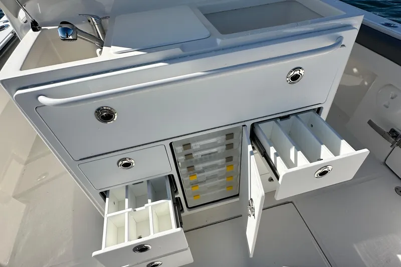 Shark Gray Yacht Photos Pics 2024 Regulator 34 boat storage compartments with drawers and sink, showcasing organized fishing gear space.