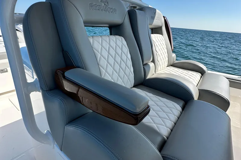 Shark Gray Yacht Photos Pics Luxurious seating on 2024 Regulator 34 boat with quilted upholstery, ocean backdrop.